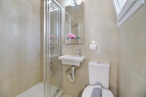 a bathroom with a toilet and a sink and a shower at M3 room in Nikiana