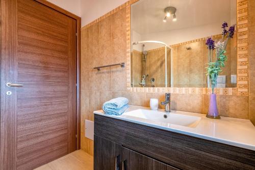 a bathroom with a sink and a mirror at Villa Felicità in Sorso