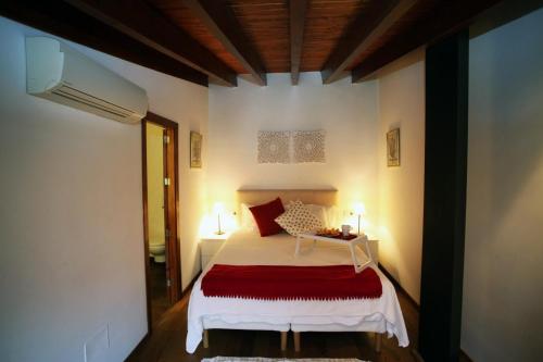 a bedroom with a white bed with a red blanket at Casa Futbol in Sóller
