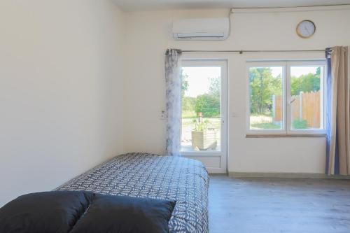 a bedroom with a bed and a window with a clock at Glycine in Paimpol