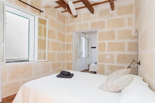 a bedroom with a white bed and a window at Casa de Ses Roques in Ciutadella