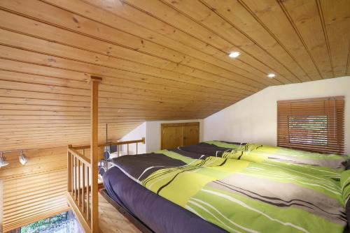 a bedroom with a bed in a wooden room at Ferienhaus am Wald mit Südblick in Steina