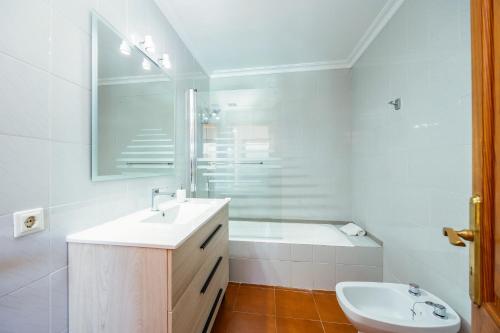 a bathroom with a sink and a tub and a toilet at Can Amer in Pollença