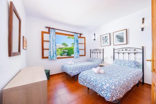 a bedroom with two beds and a window at Can Amer in Pollença