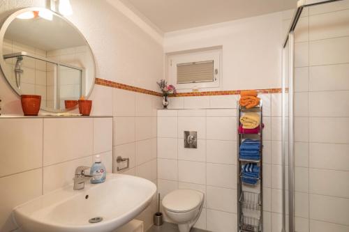 a bathroom with a sink and a toilet and a mirror at Haus Afaldra in Mengen
