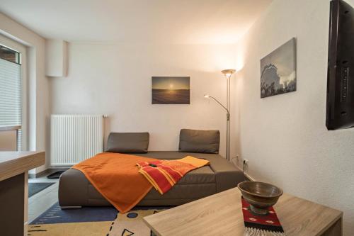 a bedroom with a bed with an orange blanket on it at Haus Afaldra in Mengen