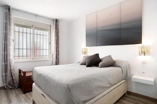a bedroom with a bed and two lamps and a window at Piso Pablo in Barbate
