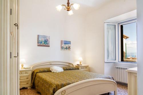 a bedroom with a bed and a window at Casa la Fortezza in Porto Santo Stefano