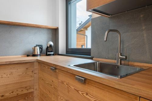 a kitchen with a stainless steel sink and a window at Luxury Ossana in Fucine