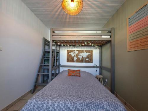 a small bedroom with a bed and a ladder at L'instant Terrière,maison de charme in La Tranche-sur-Mer