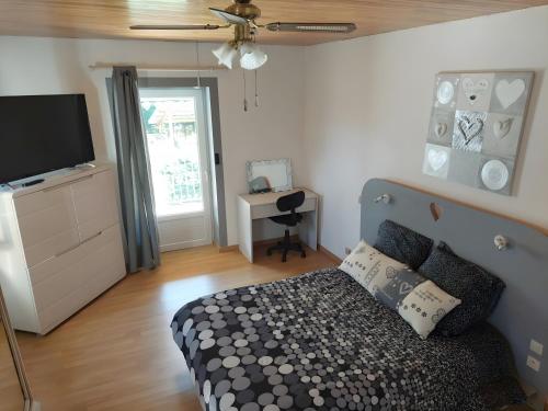 a bedroom with a bed and a flat screen tv at Séjour Nature à Campan in Campan