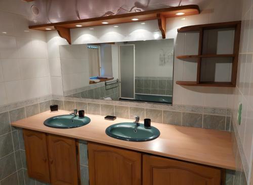 a bathroom with two sinks and a mirror at Séjour Nature à Campan in Campan