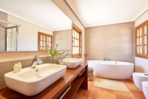 a large bathroom with two sinks and a tub at Villa Arcadia in San Jose