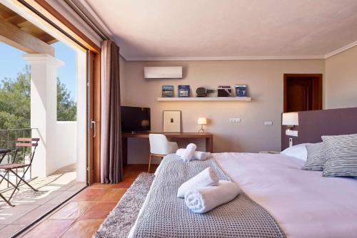 a bedroom with a bed and a desk and a balcony at Villa Arcadia in San Jose