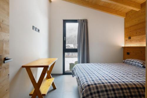 a bedroom with a bed and a desk and a window at Luxury Ossana in Fucine