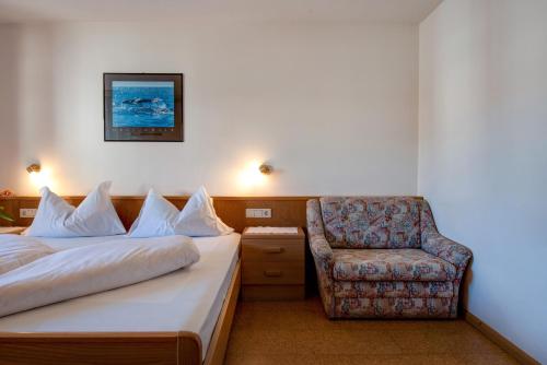a hotel room with a bed and a chair at Apartment 2 - Zur Sonne in Laion