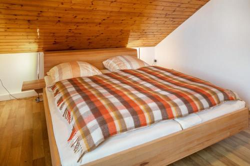 a bed in a room with a wooden ceiling at Fewo Cheny 2 mit 36qm in Titisee-Neustadt