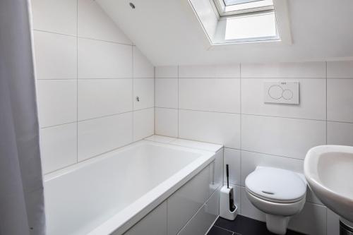a white bathroom with a toilet and a sink at Fewo Cheny 2 mit 36qm in Titisee-Neustadt