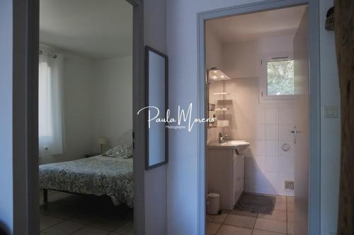a bathroom with a bed and a sink in a room at Gite Domaine Viticole, Pellerin in Montbrison-sur-Lez