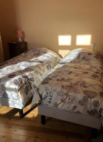 a bed with a comforter and pillows on it at Gîte Chez Claudette in Briord