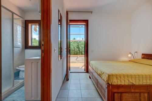 a bedroom with a bed and a bathroom with a tub at Il Sarago in Marina di Campo