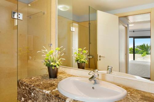 a bathroom with a sink and a mirror at Villa Pueblo Don Thomas in Playa de Santiago