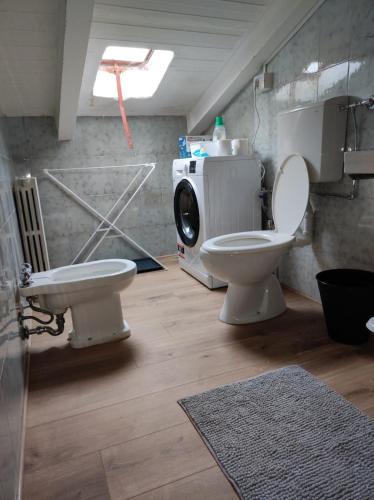 a bathroom with a toilet and a washing machine at Gnazzano Home in Loiano