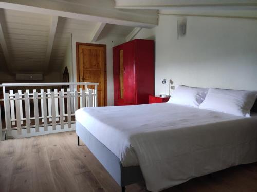 a bedroom with a large white bed and a staircase at Gnazzano Home in Loiano