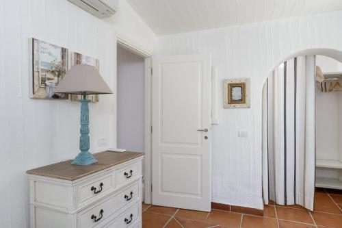 a room with a dresser with a lamp on it at Li Conchi 34 in Castiadas