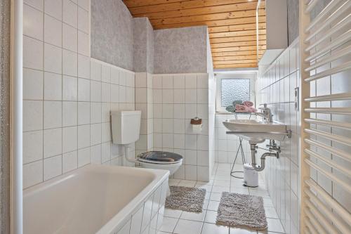 a bathroom with a tub and a toilet and a sink at Schöner Ith Blick in Salzhemmendorf