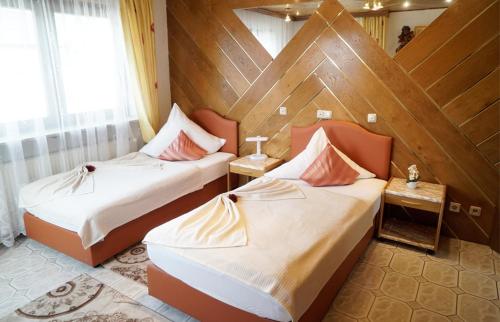Duas camas num quarto com paredes de madeira em Top Hotel Edingen em Edingen-Neckarhausen