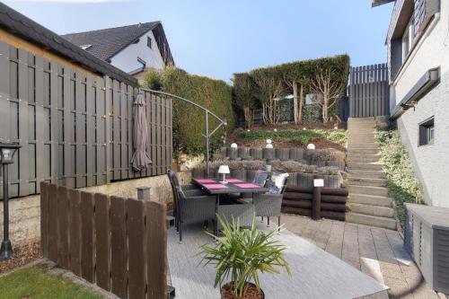 a patio with a table and chairs and a fence at Ferienwohnung Riekes in Schmallenberg