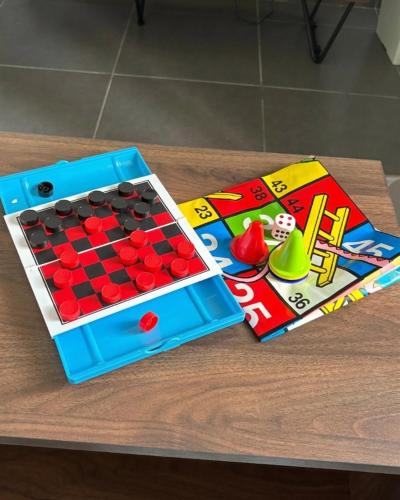 a table with a board game and a book at Kanvas 21 in Jerantut