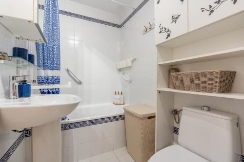 a white bathroom with a toilet and a sink at Brisa y Mar in Calahonda