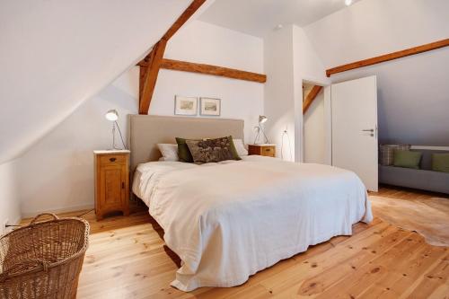 a bedroom with a large white bed in a attic at Peene Hus in Hohen Demzin