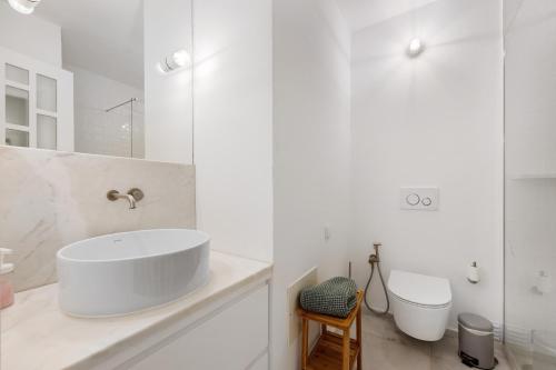 a white bathroom with a sink and a toilet at Casa da Praia in Praia de Odeceixe