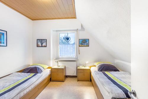 two beds in a room with a window at Ferienhaus Knappstein in Möhnesee