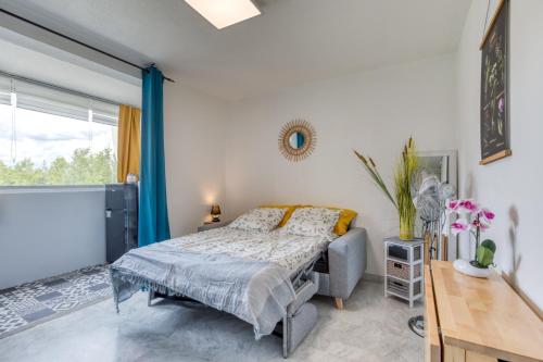 a bedroom with a bed and a large window at Le Cosy à la grande pyramide in La Grande Motte