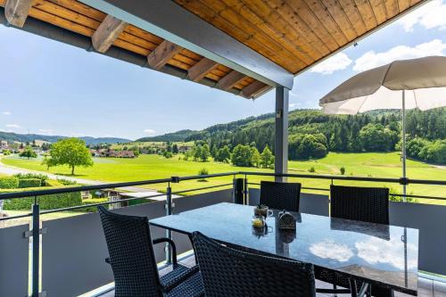 a table and chairs on a balcony with a view at Ferienwohnung Geisbergblick in Seelbach