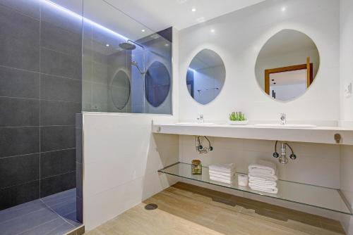 a bathroom with a shower and a sink and mirrors at Falco 1 in Corralejo