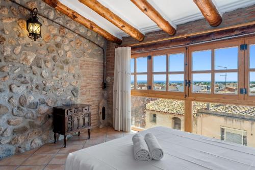 a bedroom with a stone wall and a bed and a window at Apartamento con Encanto C in Montroig