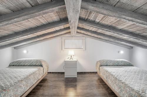 two beds in a room with wooden ceilings at Casa El Elefante in La Muela