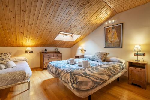 a bedroom with two beds and a wooden ceiling at Le Chalet Sierra Nevada in Monachil