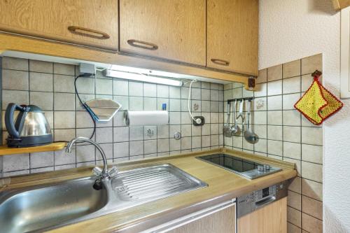a kitchen with a sink and a tiled wall at Feriewohnung Hirtenhaus in Attendorn