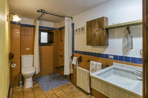 a bathroom with a toilet and a bath tub at Casa Rural Mas Fuselles in Girona