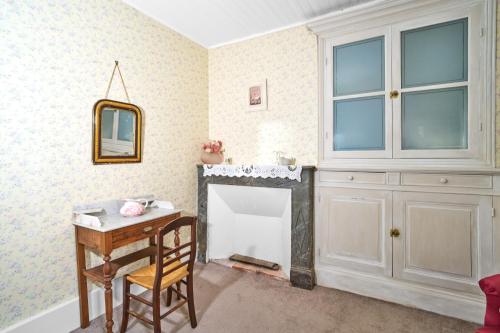 a room with a fireplace and a table and a mirror at Gite La Bessede - Dordogne in La Chapelle-Aubareil