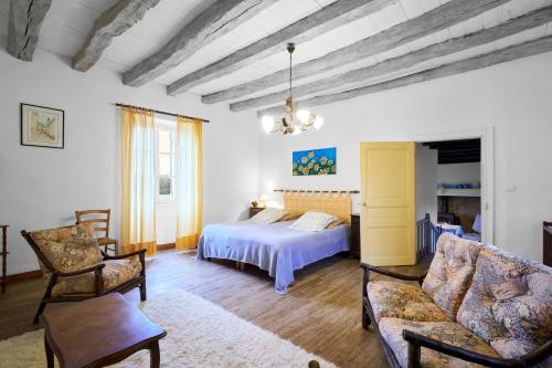 a bedroom with a bed and a couch and a chair at Gite La Bessede - Dordogne in La Chapelle-Aubareil
