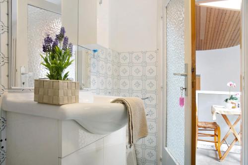 a white bathroom with a sink and a mirror at La Vecchia Torre in Porto Valtravaglia