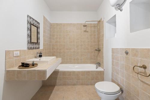 a bathroom with a tub and a toilet and a sink at I Tre Nuraghi in Tresnuraghes