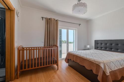 a bedroom with a bed and a crib in it at Casa d' Ana in Sesimbra